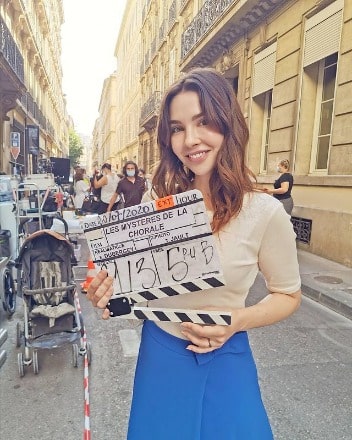 Alix posing for a photo by wearing blue and white attached outfit.